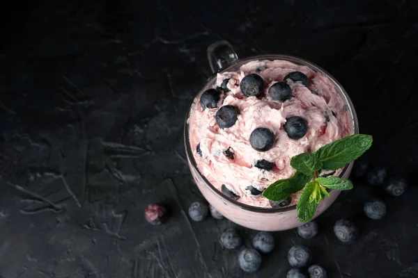 Cottage cheese dessert with cream and berries on a black background. — Stock Photo, Image