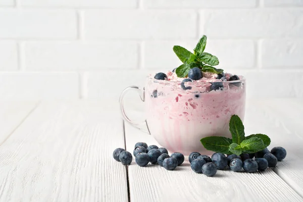 Yogurt with cream and berries on a white background. — Stock Photo, Image