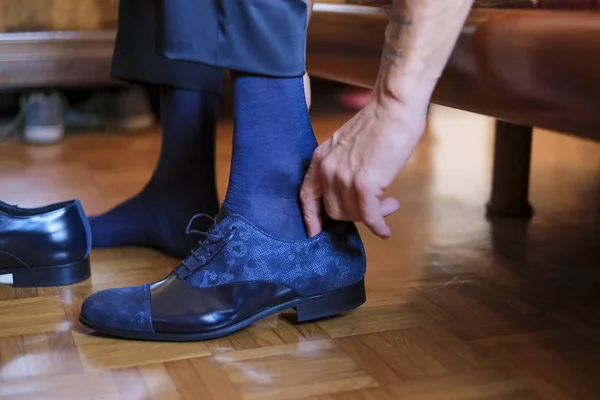 groom tying his shoes for his wedding