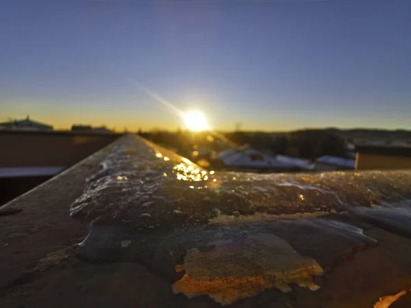 Hermoso amanecer con sol naciente y hielo en la balaustrada — Foto de Stock