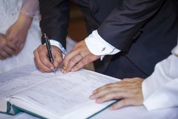 Brudgummen undertecknar bröllopshandling i kristet äktenskap — Stockfoto