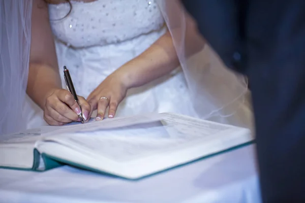 Menyasszony aláírja esküvői okirat keresztény házasság — Stock Fotó