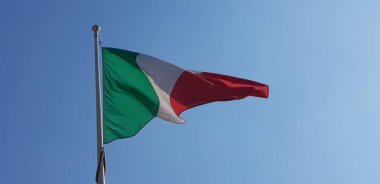 Italian tricolor flag waving on sunny day