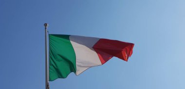 Italian tricolor flag waving on sunny day