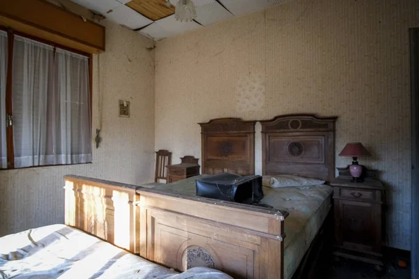Camera da letto abbandonata con letti e comodino — Foto Stock