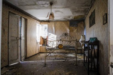 Terk edilmiş yatak odası, yataklar ve komodin.