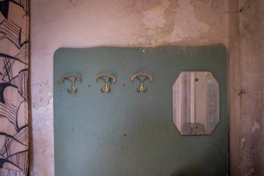 Elbise askıları ve duvar kağıtları olan eski duvar.