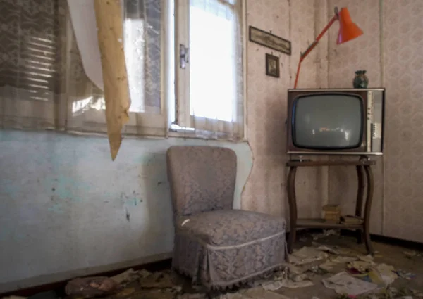 abandoned room with old television and dust cabinet
