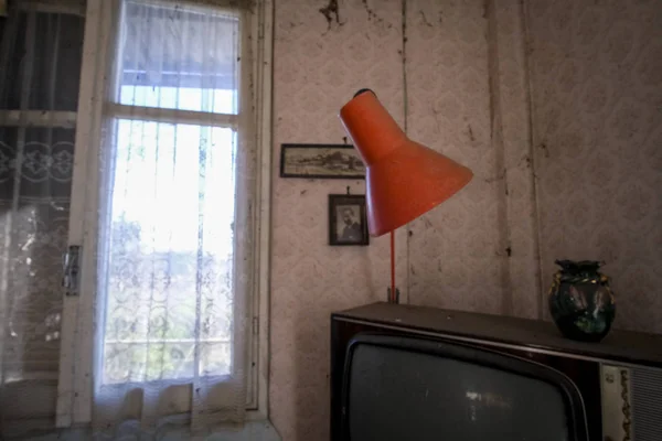 Покинутая комната со старым телевизором и пылевым шкафом — стоковое фото
