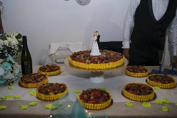 Schöne Frucht-Hochzeitstorte mit Statue des Brautpaares — Stockfoto