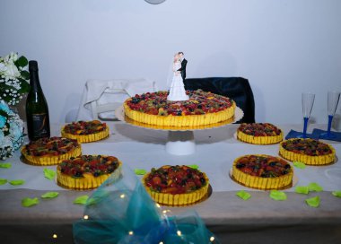 Gelin ve damat heykeli olan güzel meyveli düğün pastası