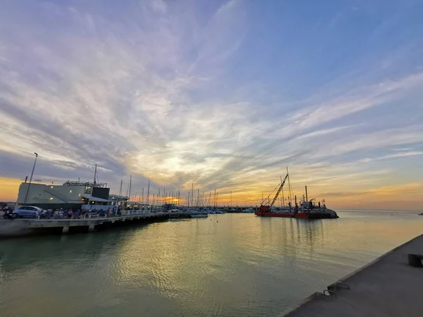 Kanaal van cervia milano marittima prachtige zonsondergang met golven en pier — Stockfoto