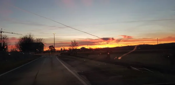 緑の丘の道の上の美しい夕日 — ストック写真