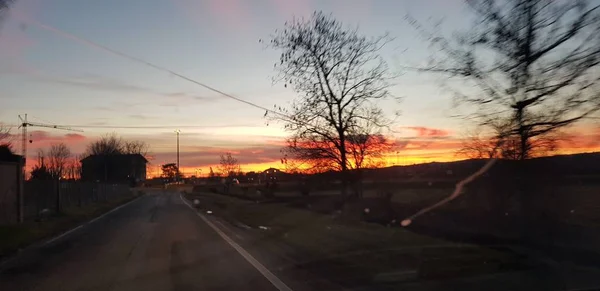 Belo pôr do sol sobre estrada colina verde — Fotografia de Stock