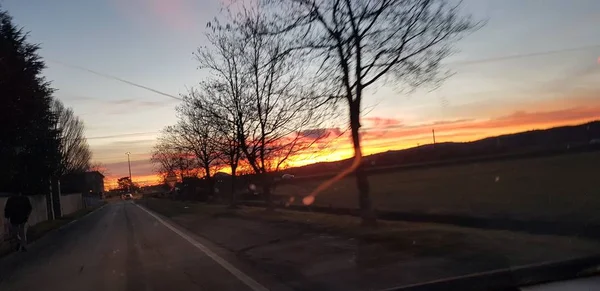 Vacker solnedgång över grön backe väg — Stockfoto
