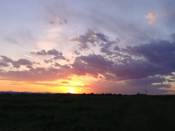 Krásný západ slunce nad zeleným kopcem silnice — Stock fotografie