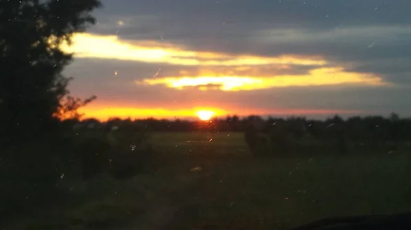 Belo pôr do sol sobre estrada colina verde — Fotografia de Stock