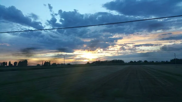 Красивий захід сонця над зеленою дорогою пагорба — стокове фото