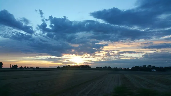 Belo pôr do sol sobre estrada colina verde — Fotografia de Stock
