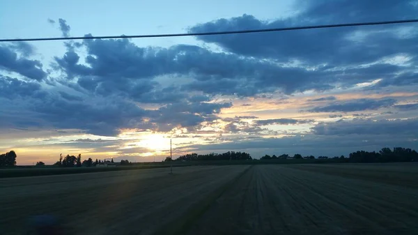 Krásný západ slunce nad zeleným kopcem silnice — Stock fotografie