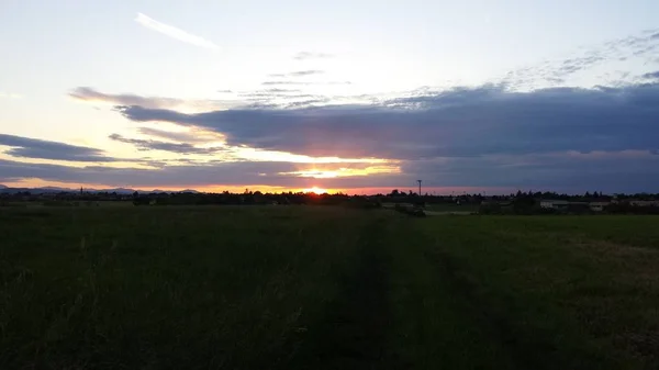 Krásný západ slunce nad zeleným kopcem silnice — Stock fotografie