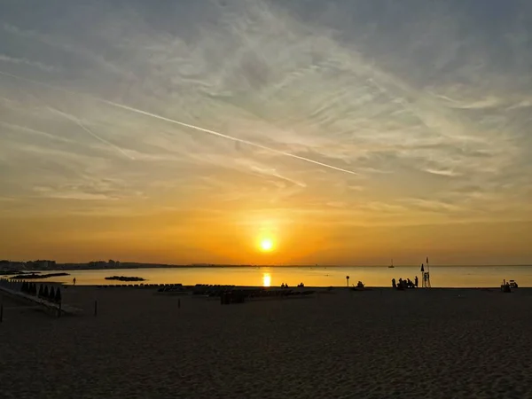 Pôr do sol na praia em riccione rimini com pessoas em silhueta — Fotografia de Stock