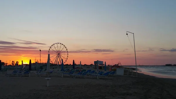 Чудовий захід сонця на пляжі Ріміні з колесом ферріса. — стокове фото