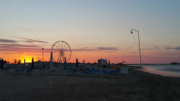 Playa de Rimini hermosa puesta de sol con noria — Foto de Stock