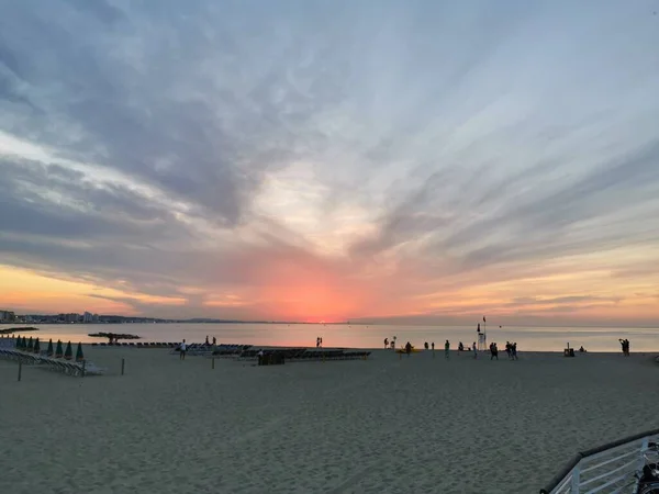 Rimini playa hermosa puesta de sol con colores brillantes y el mar — Foto de Stock