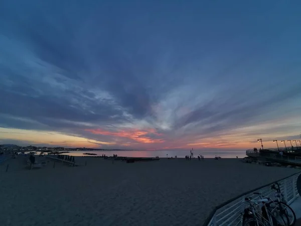 Rimini plage magnifique coucher de soleil avec des couleurs vives et la mer — Photo