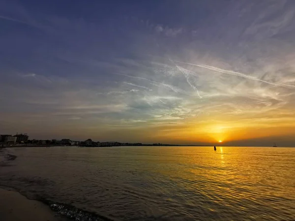 Rimini playa hermosa puesta de sol con colores brillantes y el mar — Foto de Stock