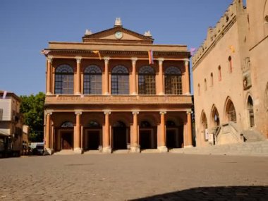 Güneşli bir günde şehrin ana meydanında belediye binasının önünde.