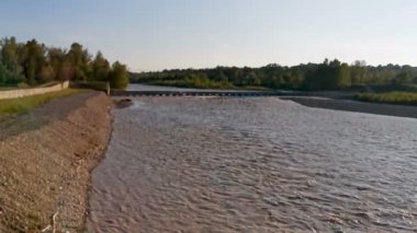Montecchio Emilia 'daki Enza Nehri. Köprüden sel basmış. Gün batımında kirli suyla dolmuş.