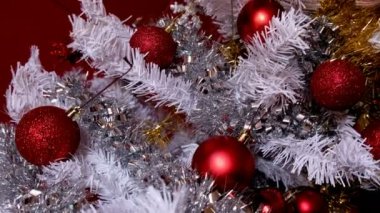 Beyaz Noel ağacında kırmızı noel balolarına göz gezdir