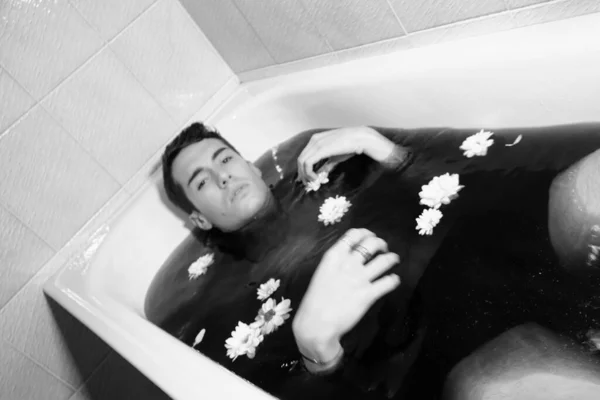 一个漂亮的男孩 身穿白衬衫 在浴缸里摆姿势吸烟 — 图库照片