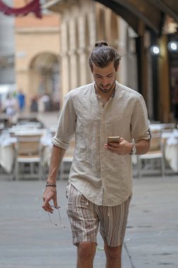 Şehirdeki güzel çocuk akıllı telefon kullanıyor.