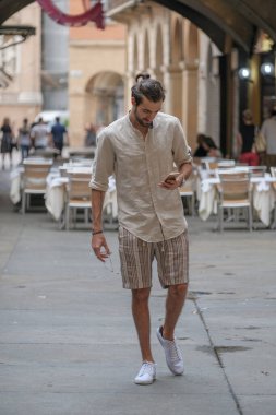 Şehirdeki güzel çocuk akıllı telefon kullanıyor.