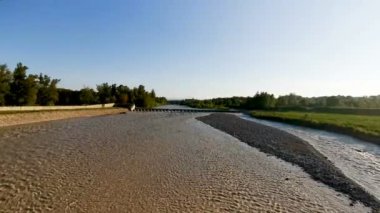 Montecchio Emilia 'daki Enza Nehri. Köprüden sel basmış. Gün batımında kirli suyla dolmuş.