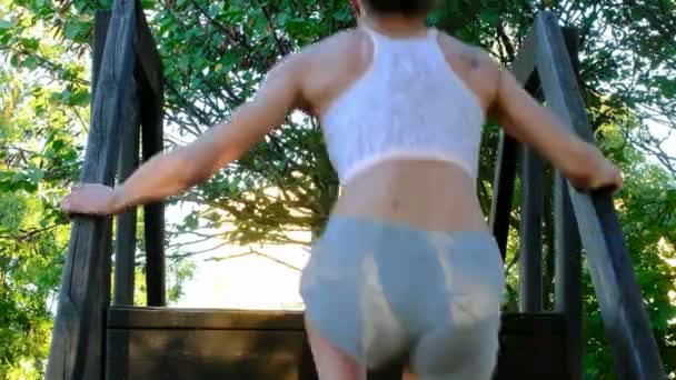 Schöne brünette italienische Mädchen macht große Schritte und Workout im öffentlichen Park — Stockvideo