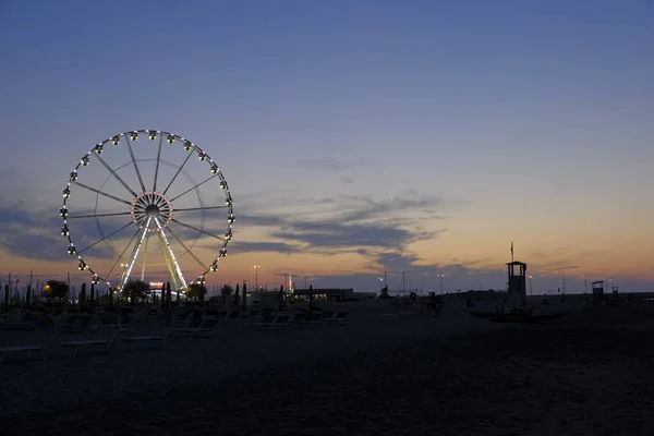 Rimini spiaggia bellissimo tramonto con colori vivaci e mare ruota panoramica — Foto Stock