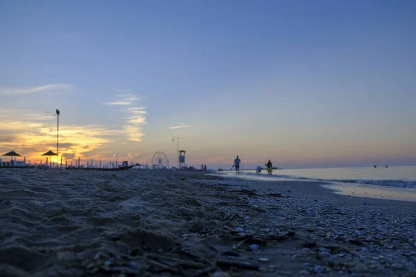 Rimini playa hermosa puesta de sol con colores brillantes y el mar — Foto de Stock