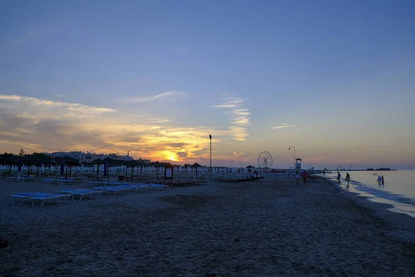 Rimini strand gyönyörű naplemente élénk színek és a tenger — Stock Fotó