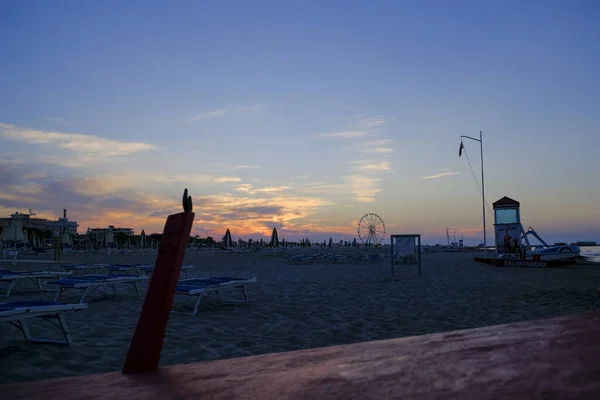 Rimini playa hermosa puesta de sol con colores brillantes y el mar — Foto de Stock