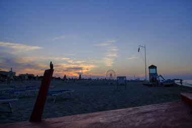 Rini plajı, parlak renkleri ve deniz panoramik tekerleği olan güzel bir gün batımı.