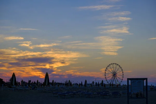 Rimini Strand schöner Sonnenuntergang mit hellen Farben und Meer-Panorama-Rad — Stockfoto