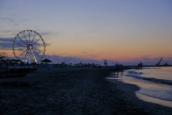 Rimini spiaggia bellissimo tramonto con colori vivaci e mare ruota panoramica — Foto Stock