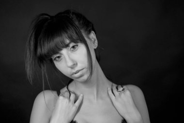 Güzel siyah saçlı, uzun saçlı ve siyah beyaz elbiseli bir kızın portresi.