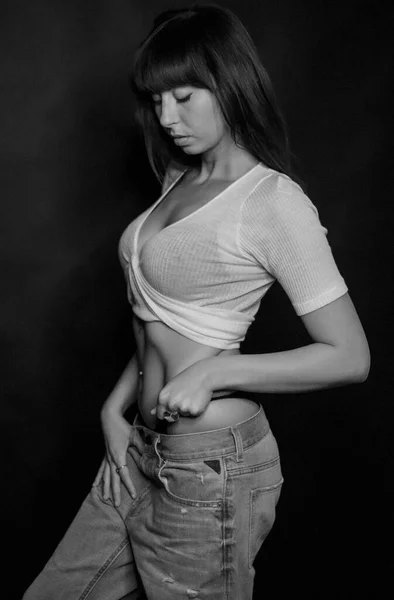 Γεμάτο σώμα από όμορφο μελαχρινό κορίτσι με χαμηλά κομμένα μακριά μαλλιά και λευκό t-shirt σε μαύρο και άσπρο — Φωτογραφία Αρχείου
