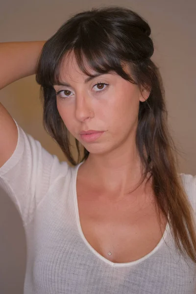 Porträtt av vacker mörkhårig flicka med lågt skuren långt hår och vit t-shirt i färg foto — Stockfoto