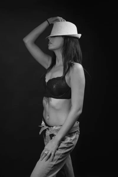 Beautiful brunette girl with long hair in underwear and white hat in black and white photo — Stock Photo, Image